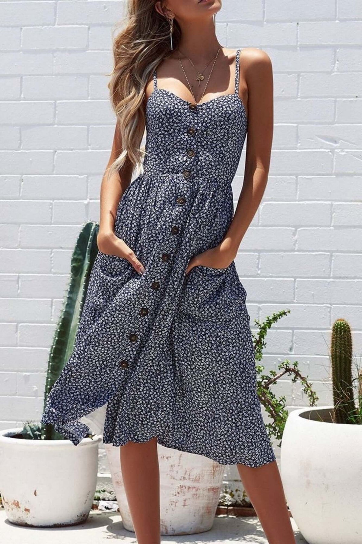 Ditsy floral sundress featuring button down design, pockets, and spaghetti straps, perfect for spring and summer occasions.