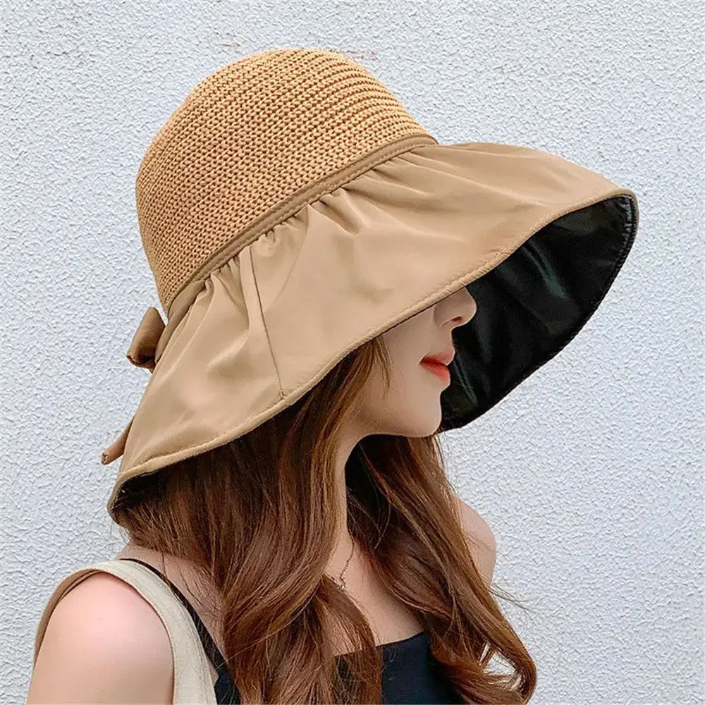 Woman wearing a stylish UPF sun protection hat with a wide brim and decorative bow, ideal for summer outings.