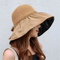 Woman wearing a stylish UPF sun protection hat with a wide brim and decorative bow, ideal for summer outings.