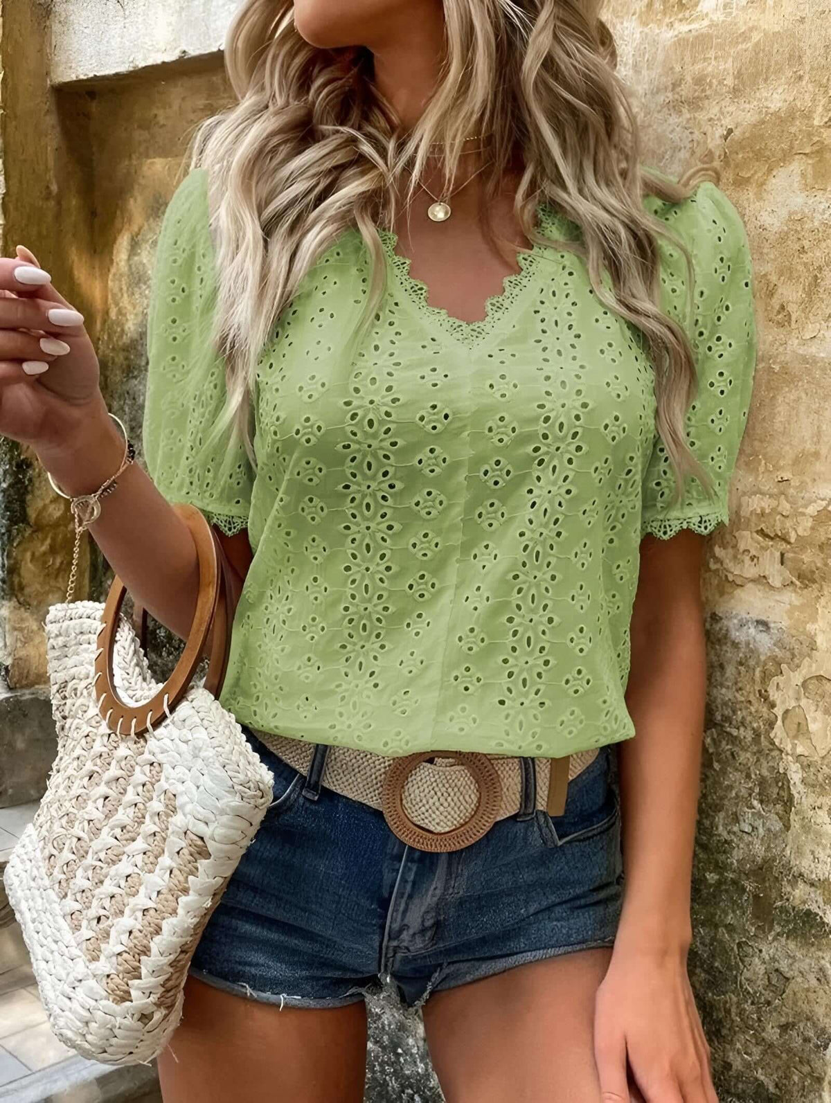 Women wearing a lace embroidery blouse in green, featuring short sleeves and a V-neck design, styled with denim shorts.